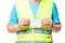 Close-up of a badge in the hands of a worker in a yellow waistcoat