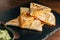 Close up Baked Chicken and Cheese Quesadillas served with Salsa and Guacamole on stone plate