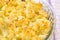 Close-up of baked fresh cauliflower with cheese and beaten egg. Round glass baking dish with tasty vegetarian food. Cook at home