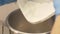 Close up baker hand pouring flour in bowl on kitchen scale in bakery shop
