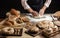 Close up of baker hands kneading dough and making bread with a rolling pin.