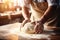 Close-up on baker\\\'s hands kneading a dough on a wooden table in bakery