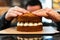 Close-up of a baker`s hands mounting a cake