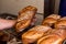 Close up of baker touching and testing fresh hadmade bread with flour in bakery shop. concept of passion and care for a handmade t