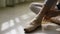 Close-up of ballerina`s feet. Ballerina preparing for training, and tying ribbon of pointe shoes sitting on floor in