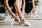 Close up for ballet dancer putting on, tying ballet shoes. Ballerina putting on her pointe shoes