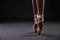 Close up of of ballet dancer`s feet over gray