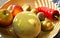 Close up bamboo fruit basket with melon, apples, kiwis, bell pepper illuminated by evening sun beams