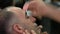 Close up of barber removing hair by sugaring from face of turkish man.