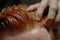 Close-up of a barber\\\'s skilled hands crafting a perfect hairstyle