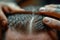 Close-up of a barber\\\'s skilled hands crafting a perfect hairstyle