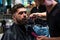 Close-up of barber styling beard to male in barbershop, Personal stylist barber