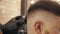 Close up barber stylist using hair trimmer for male hairstyle. Male haircut with electric shaver. Hair dressing in