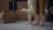 Close-up of the bare feet of an unrecognizable husband and wife against the background of cardboard boxes with things