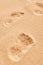 Close up on a bare footprint in granular sand