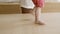 Close-up of barefoot little boys legs walking on table.