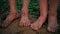 Close-up barefooted dirty feet of a children standing on a damp ground