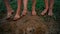 Close-up barefooted dirty feet of a children standing on a damp ground