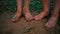 Close-up barefooted dirty feet of a children standing on a damp ground