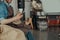 Close up of barista with cup of coffee and phone sit on warehouse of coffee factory