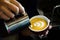 Close up barista hands pouring froth milk in espresso coffee cup for making latte art