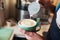 Close up barista hands pouring warm milk in coffee cup for making latte art.Professional coffee latte art in coffee shop