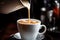 close-up of a barista pouring steamed milk into a coffee cup