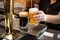 Close up of barman hand at beer tap pouring a draught lager beer