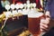 Close-up of barman hand at beer tap pouring a draught lager beer.