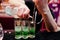 Close up barman hands preparing green mexican cocktail drink at
