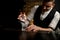 Close-up. Bartender holds in hand tweezers with ice over steaming glass and look at it