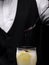 Close-up of a bartender pouring topping on a cocktail on a black background. Party drinks. Cocktail preparation concept.