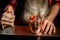 Close-up bartender sprinkles on metal cup with slices of citrus