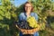 Close-up basket with green and blue grapes in hands of woman