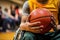 close-up of a basketball in a players hand whos in a wheelchair