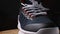 Close-up of a basketball sneaker on a wooden surface. Dark background. View of the front and outside of the shoe. Camera