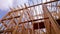 Close-up of beam built home under construction and blue sky with wooden truss, post and beam framework. Timber frame house, real