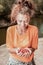 Close up of beaming happy woman after gathering some red berries in forest