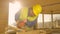 CLOSE UP: Bearded contractor diligently sands a wooden beam with a sander.