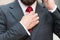 Close up of bearded man touching red tie while talking on the phone