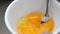 Close up beating eggs in a white bowl. The omelette is one favorite menu