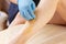 Close-up Of A Beautician shugaring depilation Woman`s Leg In Beauty Spa. Body hair removal