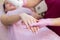 Close-up of a beautician sprinkles talcum powder on a young girl`s hand before the depilation procedure. The girl lies