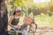 Close up Beautiful Asian woman in green singlet sitting and working with laptop under the tree next to a white bicycle in a public