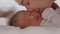 Close up Beautiful Attractive Asian mom kissing on baby cheek sweet and lovely with love.Cute Asian newborn sleeping and napping