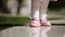 Close-up of the beautiful baby-girl standing in the park at sunlight day.