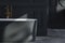 Close up beautiful black-white bathtub wtih golden faucet in classical bathroom.