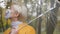 Close up. Beautiful blond woman with face mask holding transparent umbrela in the park in autumn