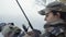 Close-Up, beautiful fisherwoman girl in camouflage suit pulls fishing rod from the river and checks the lure on the hook