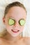 Close up of beautiful girl with facial mask of cucumber